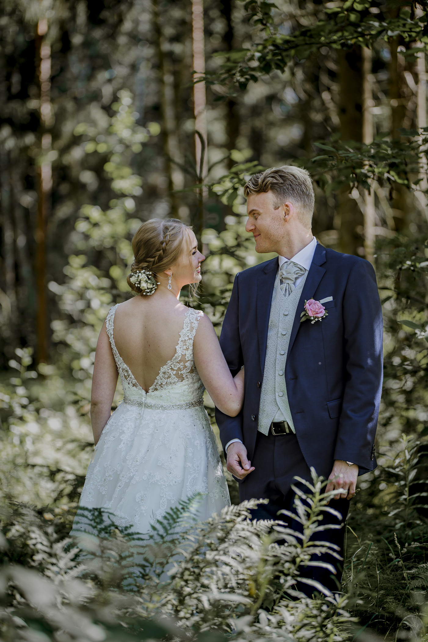 Brudpar under sin bröllopsfotografering i en skog utanför stockholm