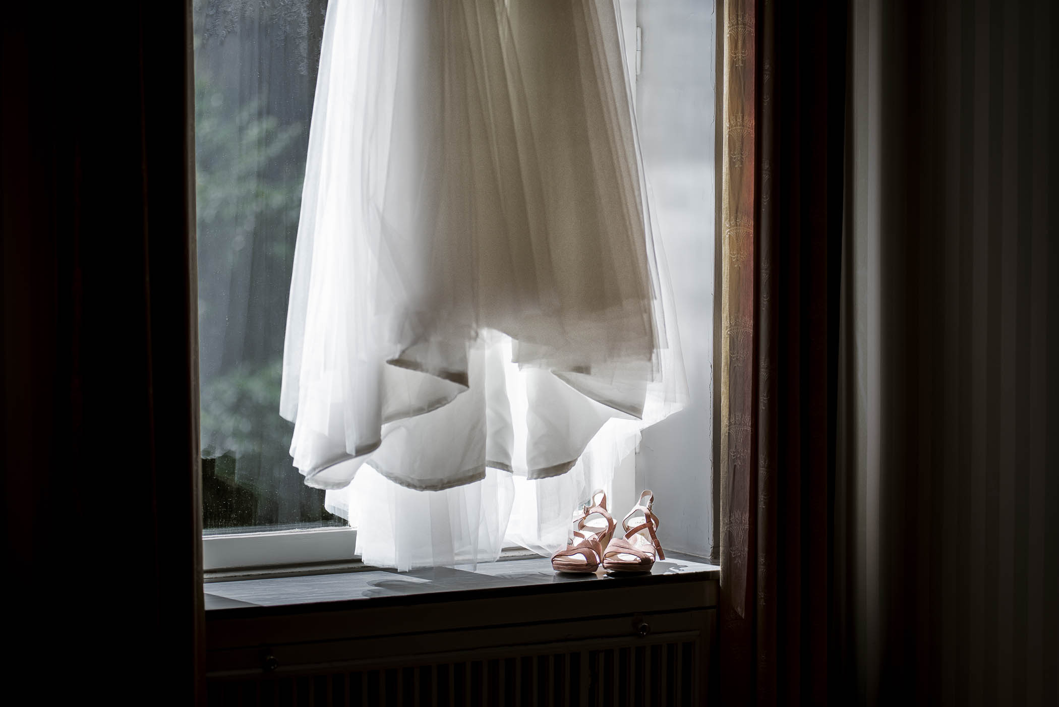Brudklänning och skor hängandes i fönster