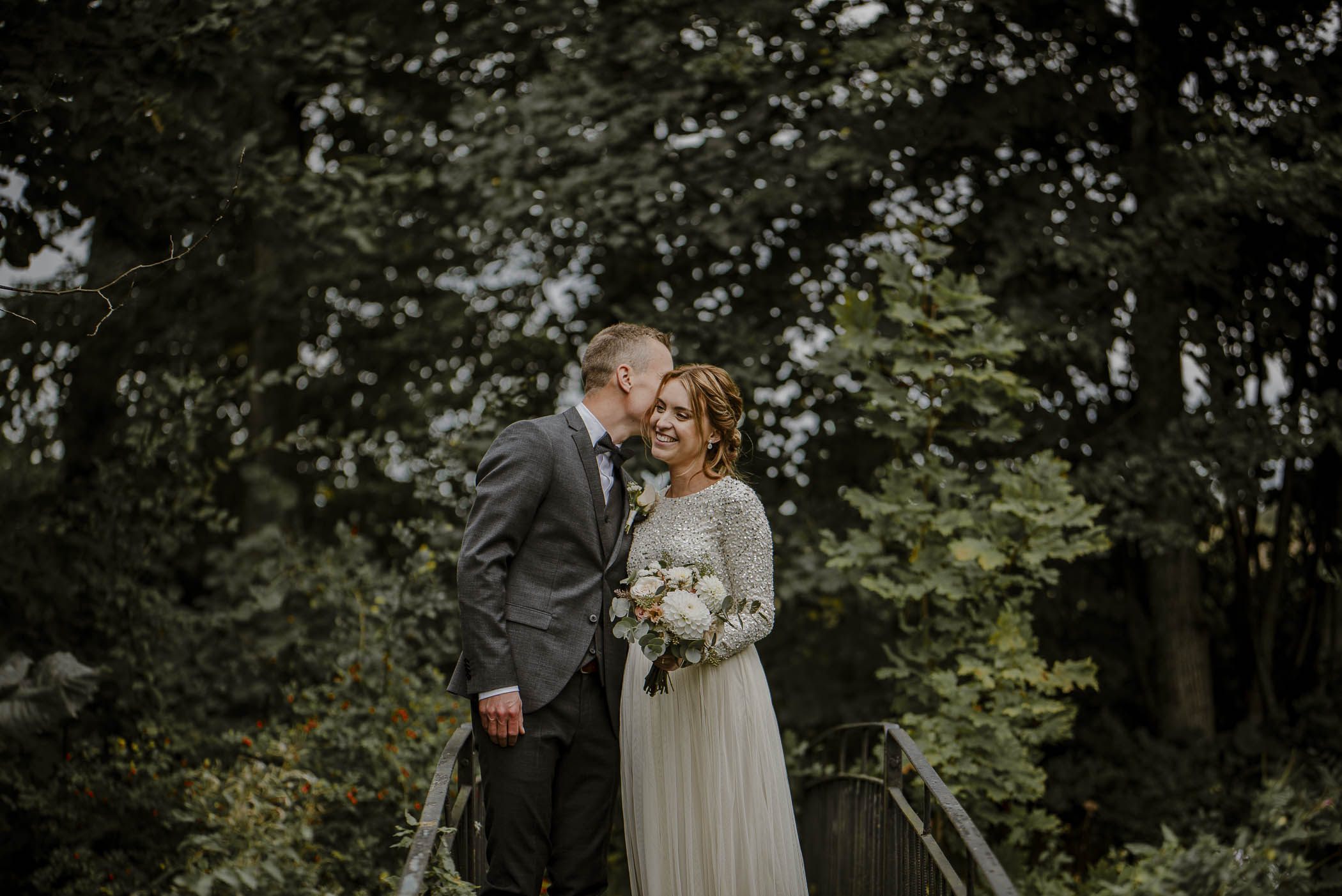 Brudpar under deras bröllopsfotografering vid rosendals trädgård utanför stockholm