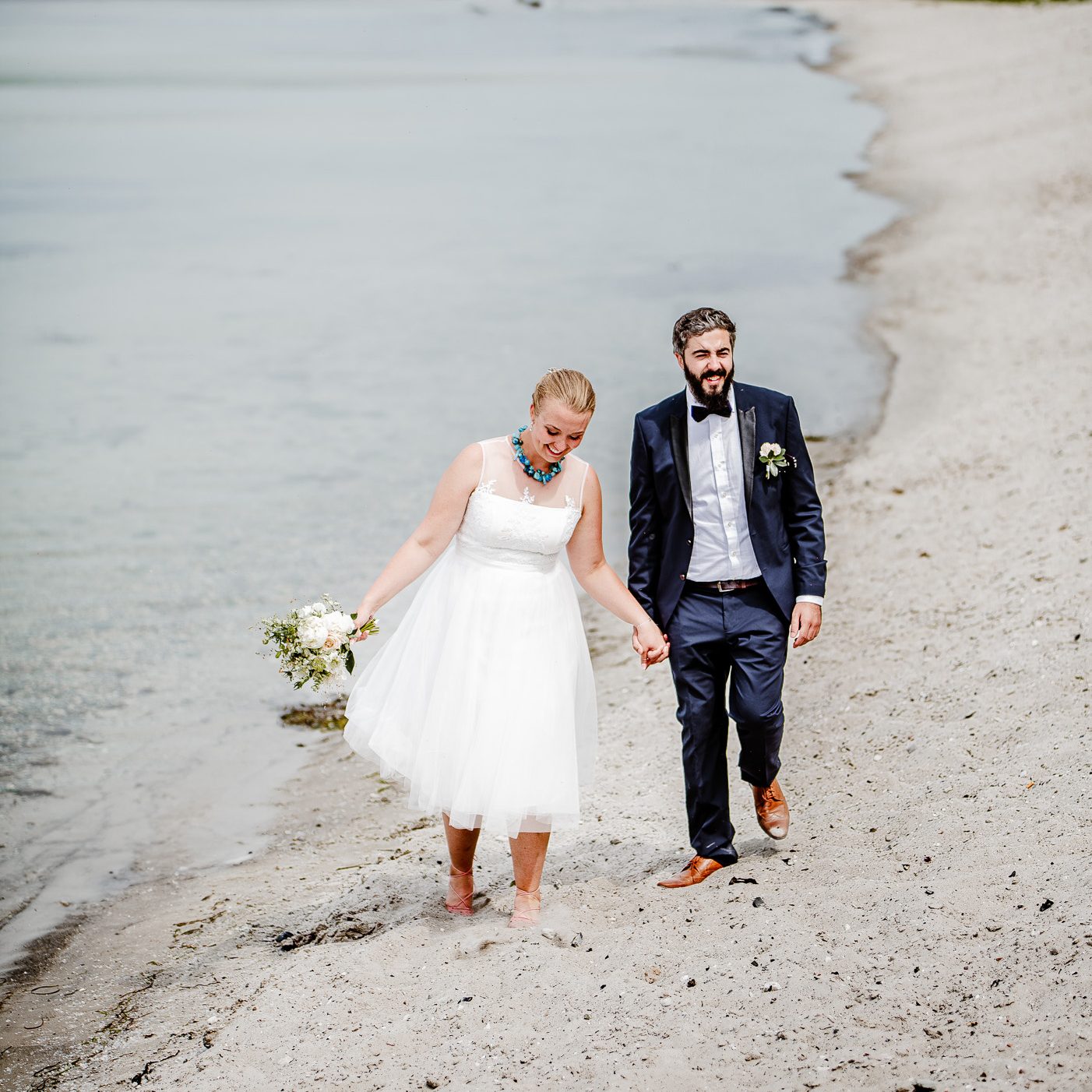 Brudpar under sin bröllopsfotografering på stranden i Klagshamn, Skåne