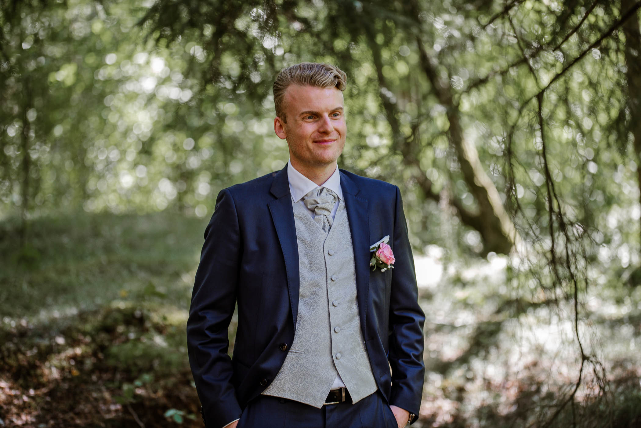 Brudgum under bröllopsfotografering i skogen i Stockholm